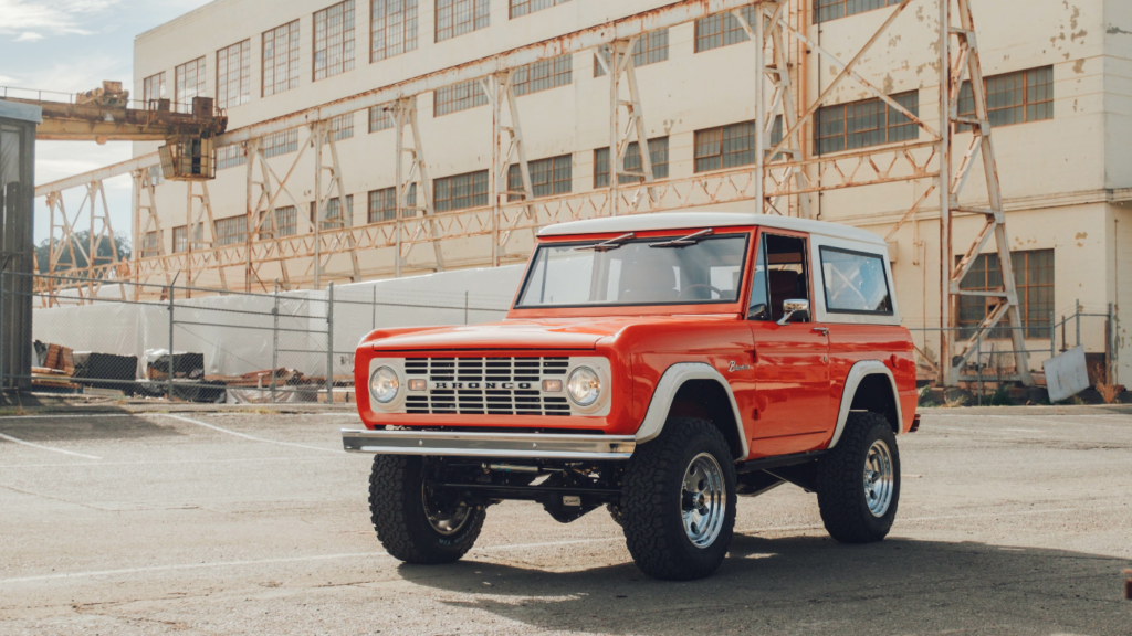 Cover image from an article highlighting the first commercial Bronco to come off Kindred's factory floor. It shows a beautiful vintage Ford Bronco in front of an industrial building. 